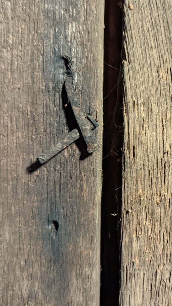 floor boards in basement with old square nails showing re-use